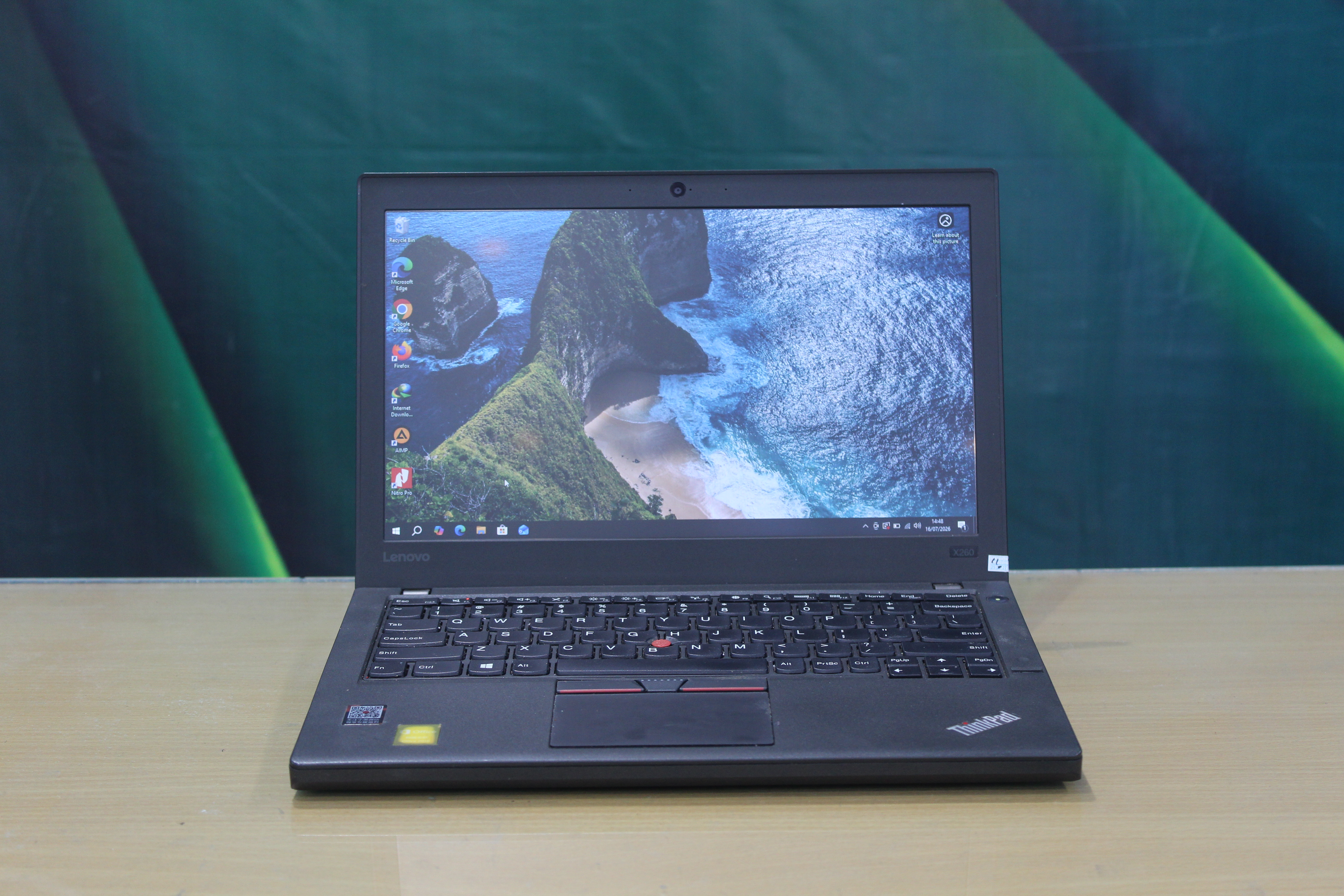 A sleek laptop and smartphone placed on wooden flooring, showcasing contemporary technology.